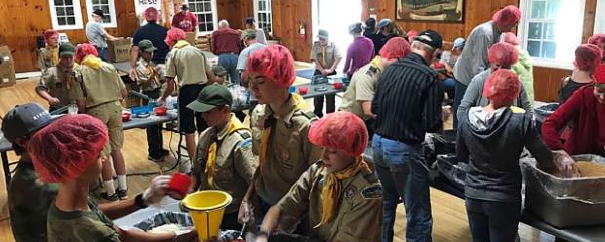 Trinity parishioners and Scouts pack meals for food-insecure children.