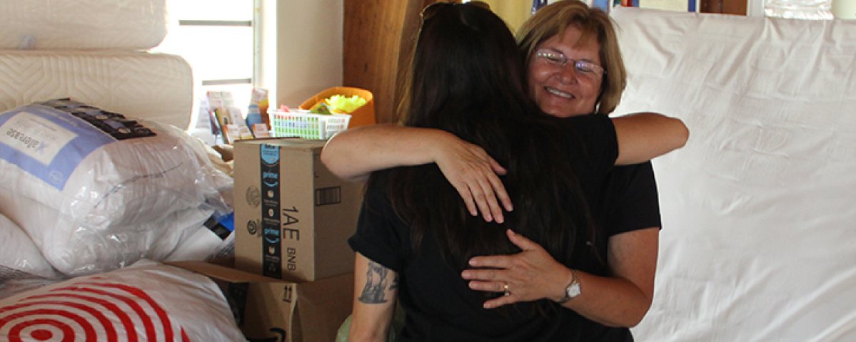 Rev. Debra of St. Columba is hugging a recipient of disaster support