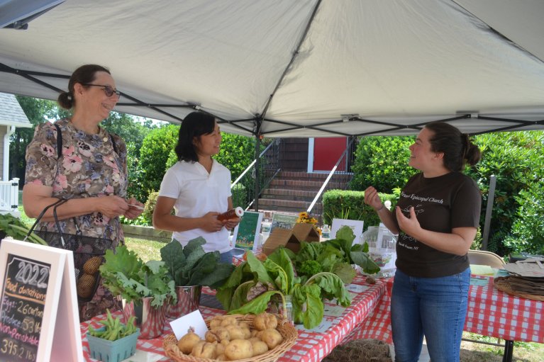 Beth Baier from North Merrick, and Amy Long, who teaches Brain and Body Yoga Classes at the church, chatted with Kristin Talbot about some of the produce. (Photo: TIM BAKER/HERALD)