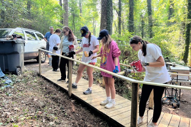 Towel Ministry campers paint a newly installed railing. 