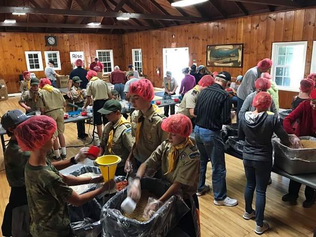 Trinity parishioners and Scouts pack meals for food-insecure children.