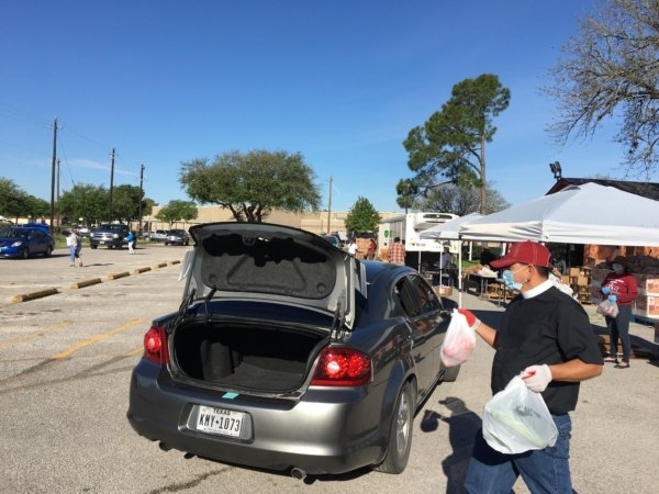 The Rev. Pedro López, vicar of Iglesia Episcopal San Pedro in Pasadena, Texas, helps distribute food during its food drive.