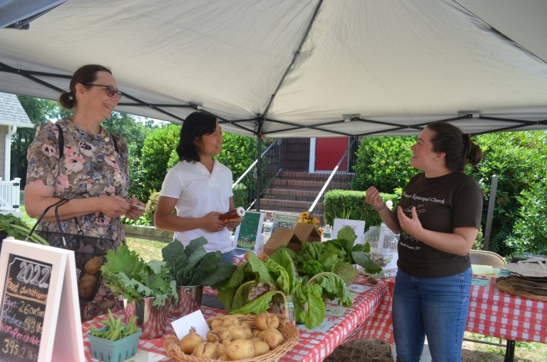 Beth Baier from North Merrick, and Amy Long, who teaches Brain and Body Yoga Classes at the church, chatted with Kristin Talbot about some of the produce. (Photo: TIM BAKER/HERALD)