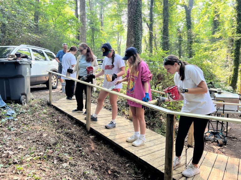 Towel Ministry campers paint a newly installed railing. 